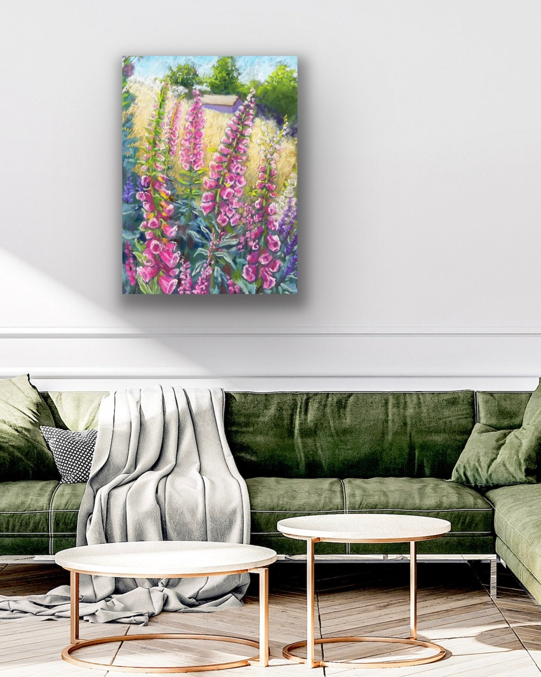 Pink foxgloves in the foreground with a field and building in the background landscape