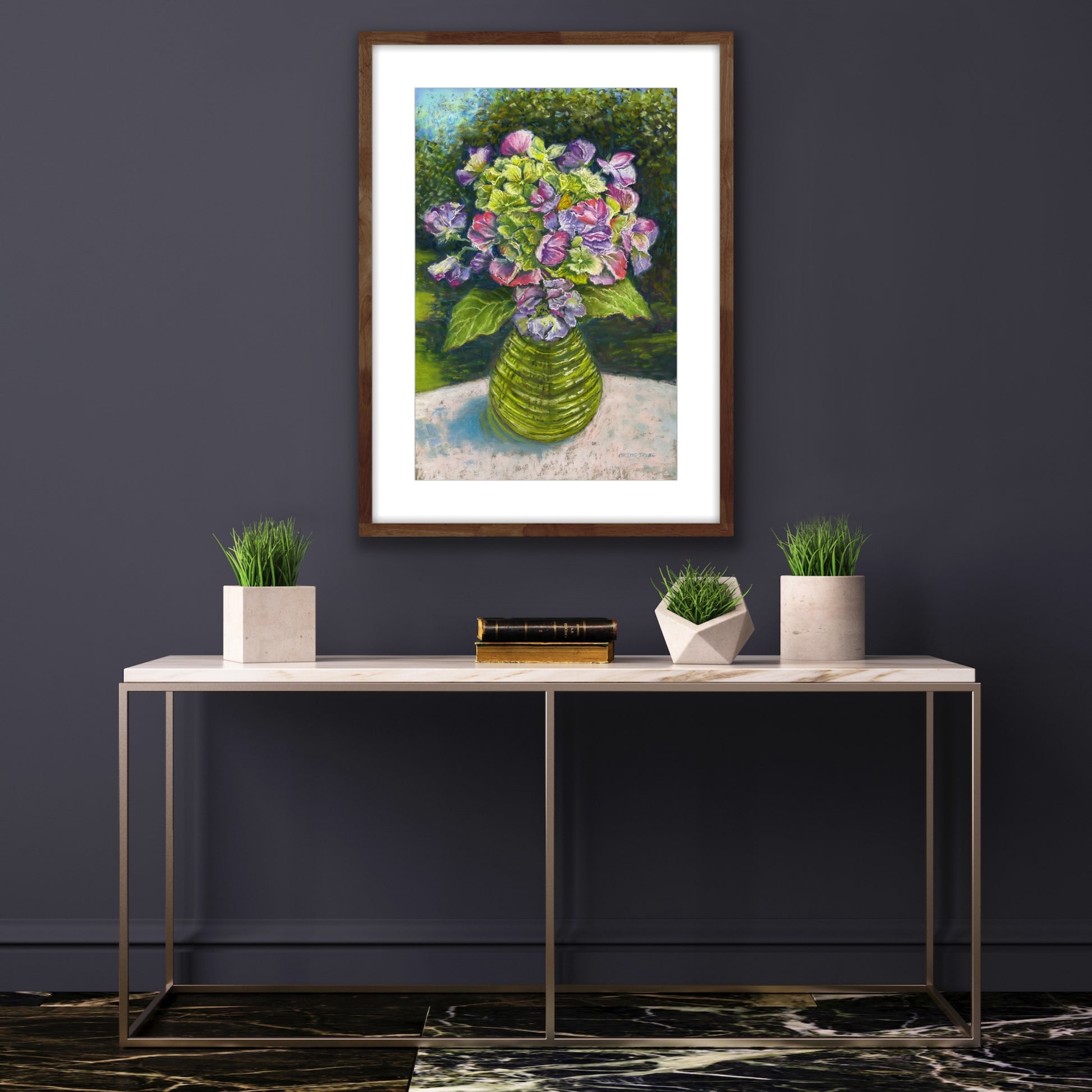 Sweetpeas and hydrangeas in a glass jar on a table cloth with dappled sunlight and trees and garden behind