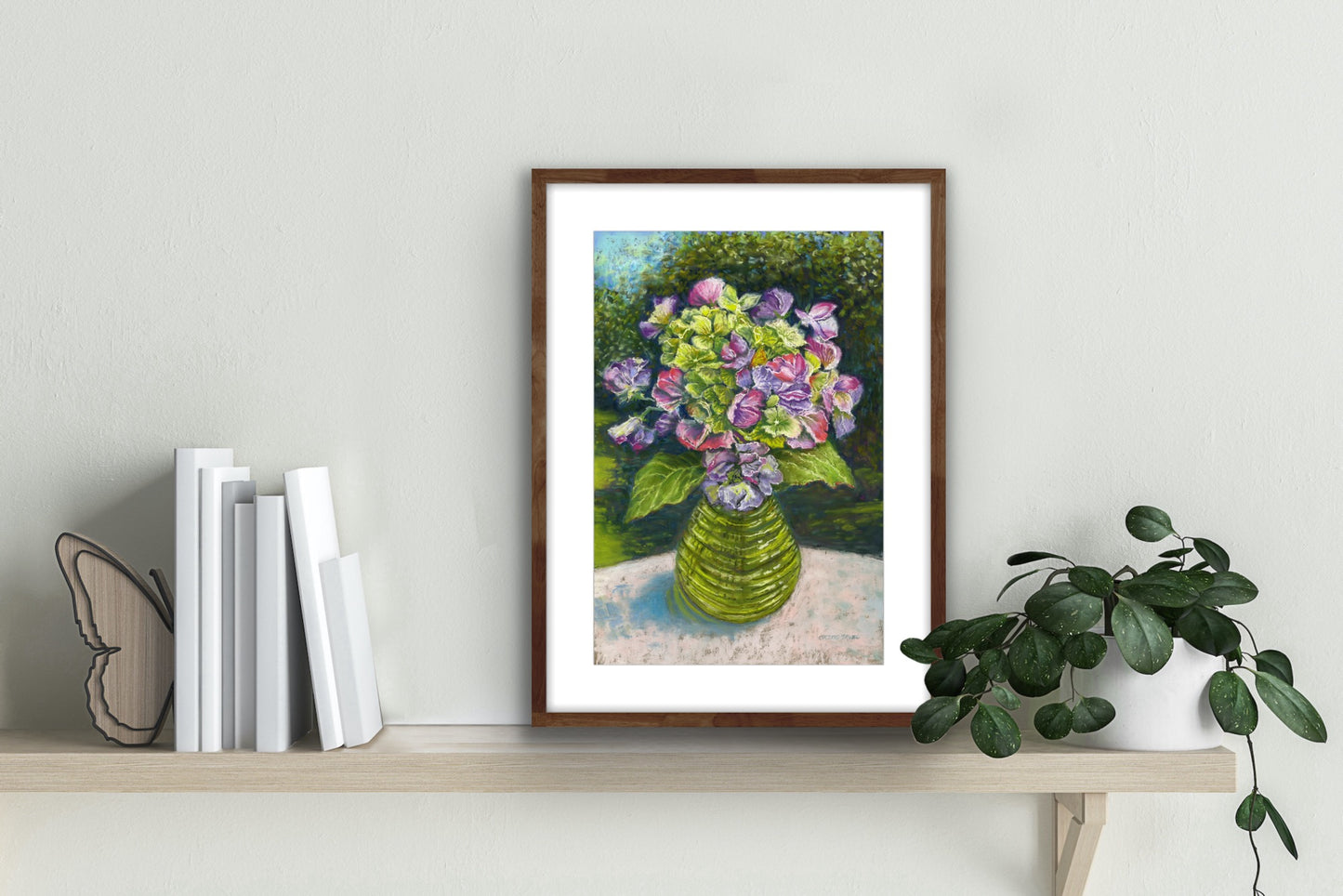 Sweetpeas and hydrangeas in a wasp catcher on a table cloth with trees, garden and dappled sunlight in the background