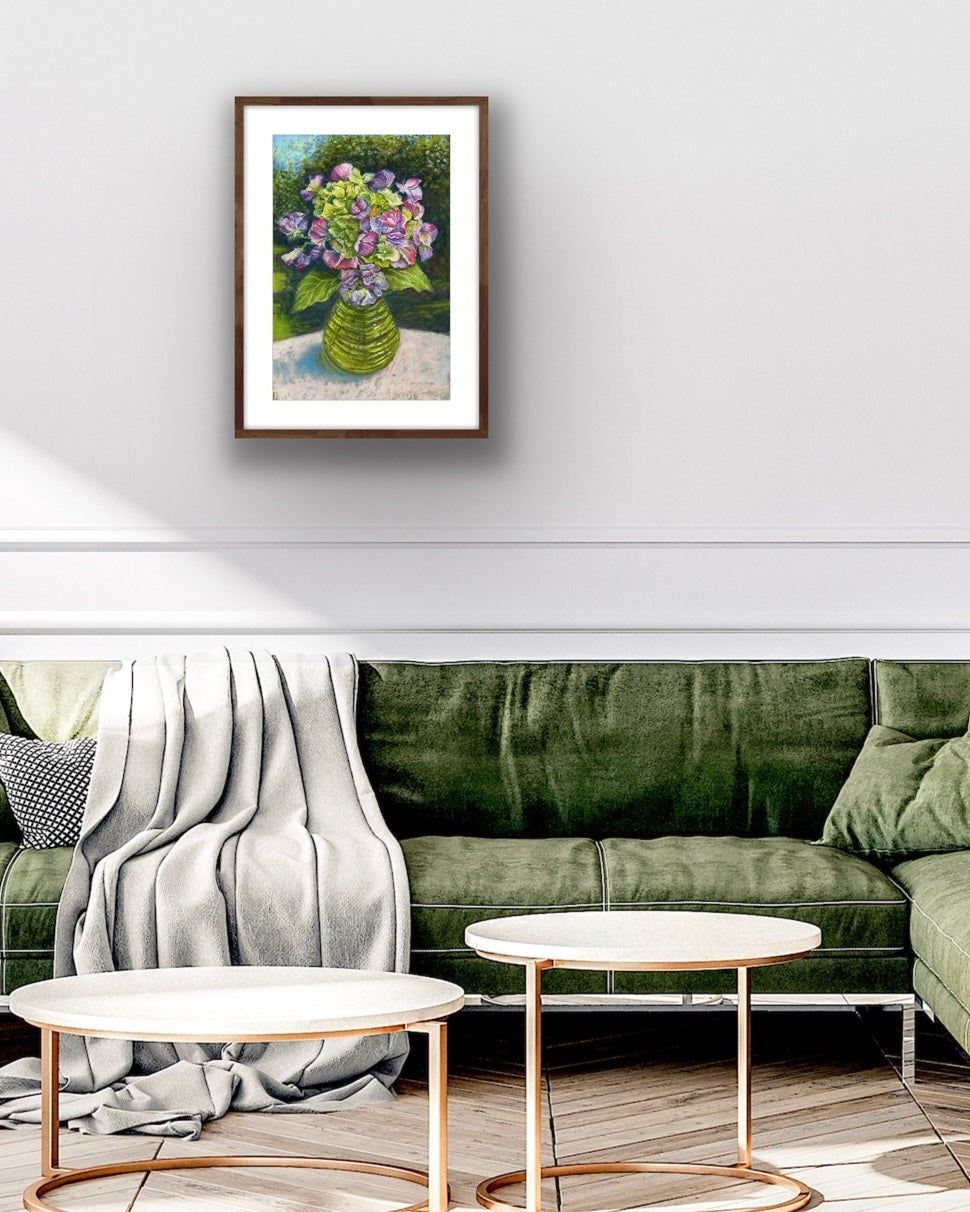 flowers in a glass jar on a table cloth with dappled sunlight trees and garden behind