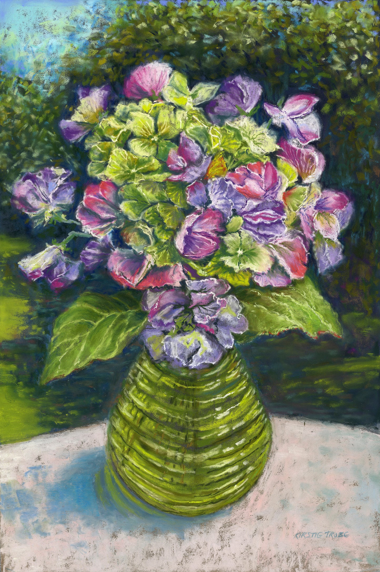 Sweetpeas and hydrangeas in a glass jar on a table cloth with dappled sunlight and trees and garden behind