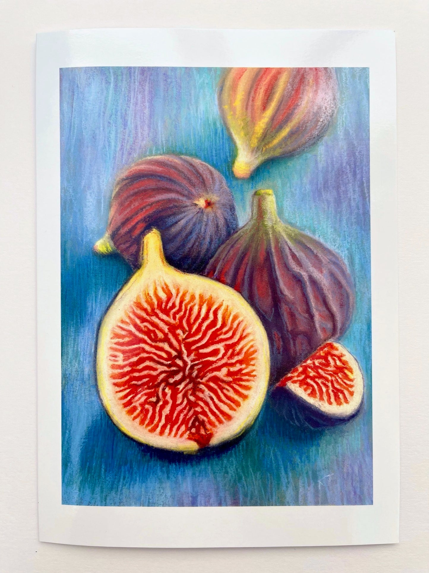 A pastel still life of several figs, depicted as whole and sliced. The vibrant, bright colours of their flesh contrasting with the muted tones of their skins are set against the turquoise and mauve background.